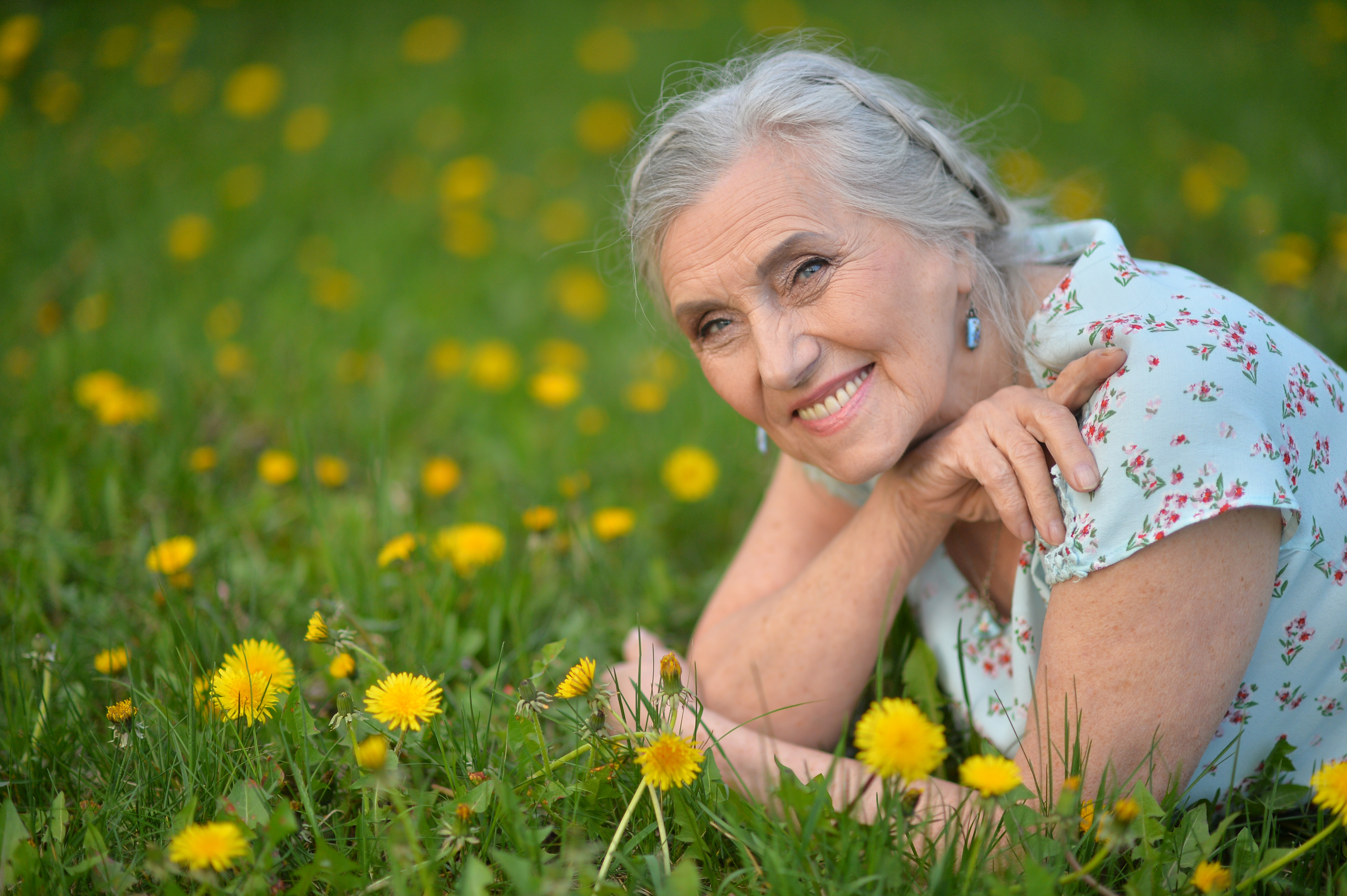 Vanha nainen loikoilee niityllä