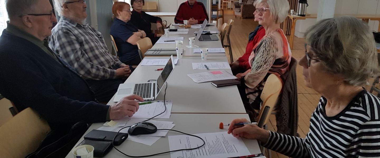 ihmisiä pöydän ympärillä