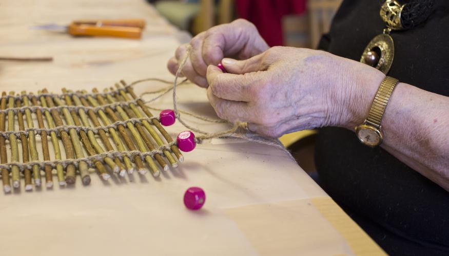 Nainen punoo pajusta kaitaliinaa